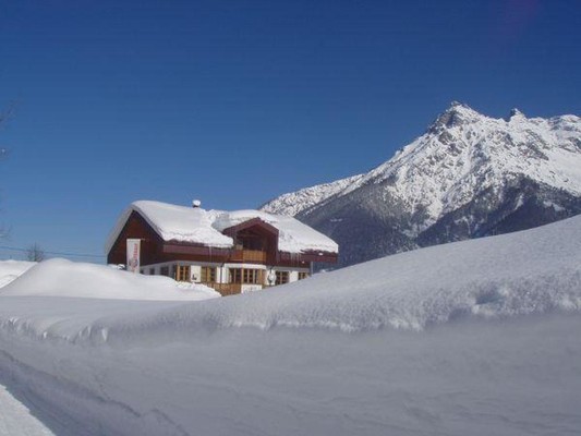 Hiking trail with view of the house in deep snow